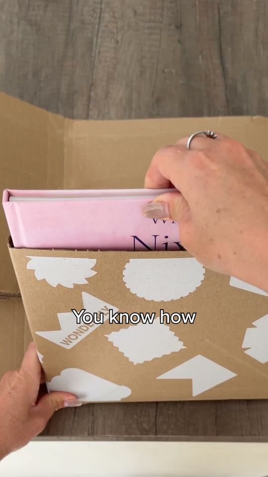 A hand pulling a pink hardcover out of a cardboard sleeve, caption: You know how